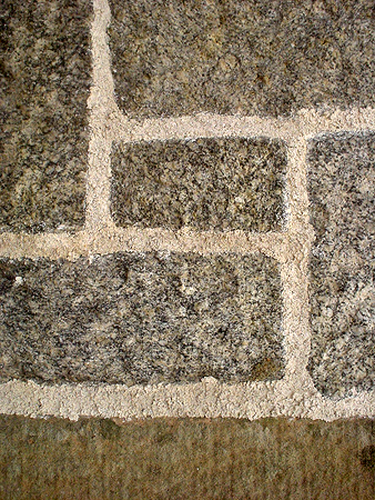 Pointed with open textured finish to squared granite coursed masonry.