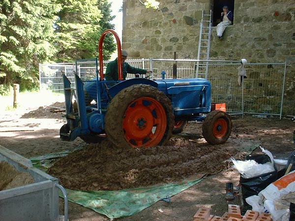 Puddling earth: mechanical help prior to spreading and compacting with a mechanical packer.